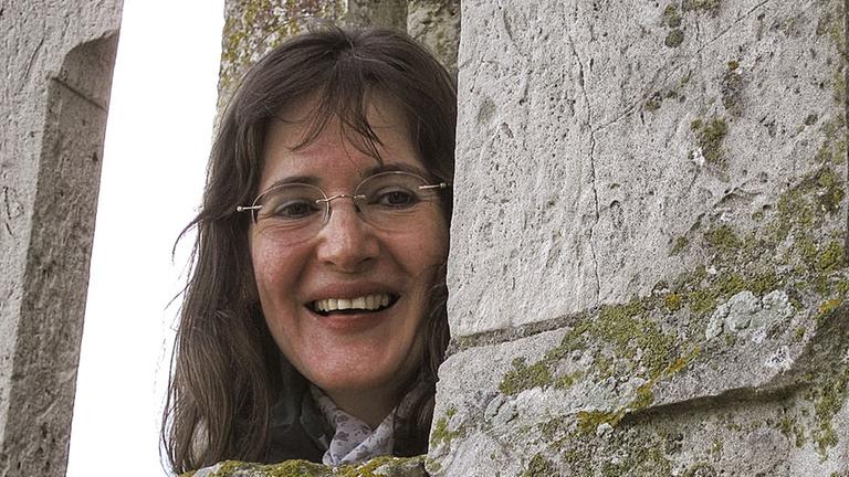 Die Reiseleiterin Marianne Quast schaut hinter einer Säule der Kathedrale von Chartres hervor. Die Reiseleiterin Marianne Quast schaut hinter einer Säule der Kathedrale von Chartres hervor.