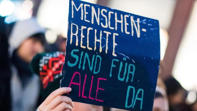 Bei einer Demonstration in Frankfurt hält eine Frau ein Schild mit der Aufschrift "Menschenrechte sind für alle da".