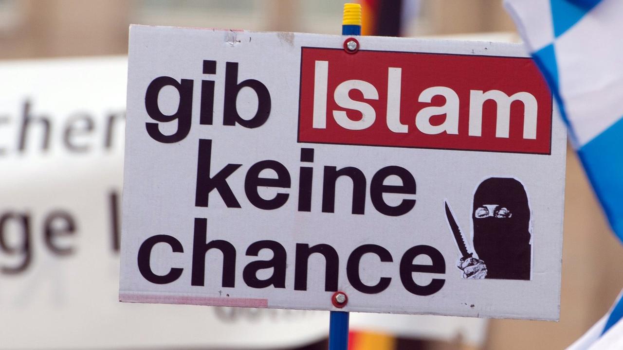 Ein Anhänger des islamkritischen Pegida-Bündnisses hält während einer Kundgebung ein Schild mit der Aufschrift "gib Islam keine chance". Ein Anhänger des islamkritischen Pegida-Bündnisses hält während einer Kundgebung ein Schild mit der Aufschrift "gib Islam keine chance".