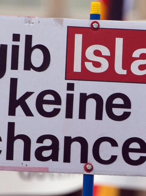 Ein Anhänger des islamkritischen Pegida-Bündnisses hält während einer Kundgebung ein Schild mit der Aufschrift "gib Islam keine chance".