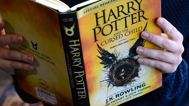 Eine Frau hält das Buch "Harry Potter and the Cursed Child Parts I & II" von Joanne K. Rowling am 25.08.2016 in Berlin im "English Bookshop" im Kulturkaufhaus Dussmann in den Händen.