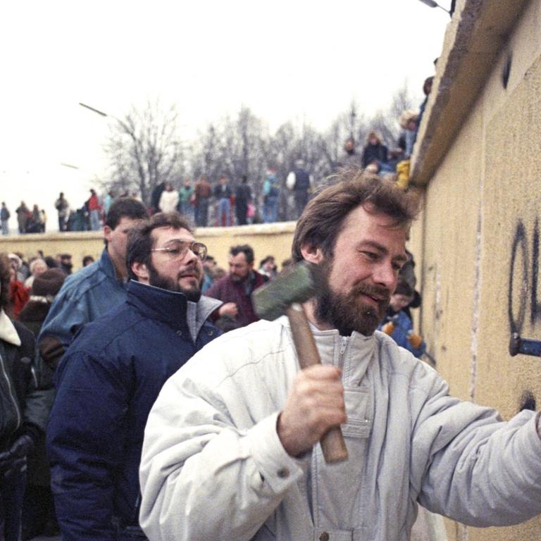 Berliner klettern auf und über die Mauer am Brandenburger Tor und Mauerspechte hämmern, 01.01.1990