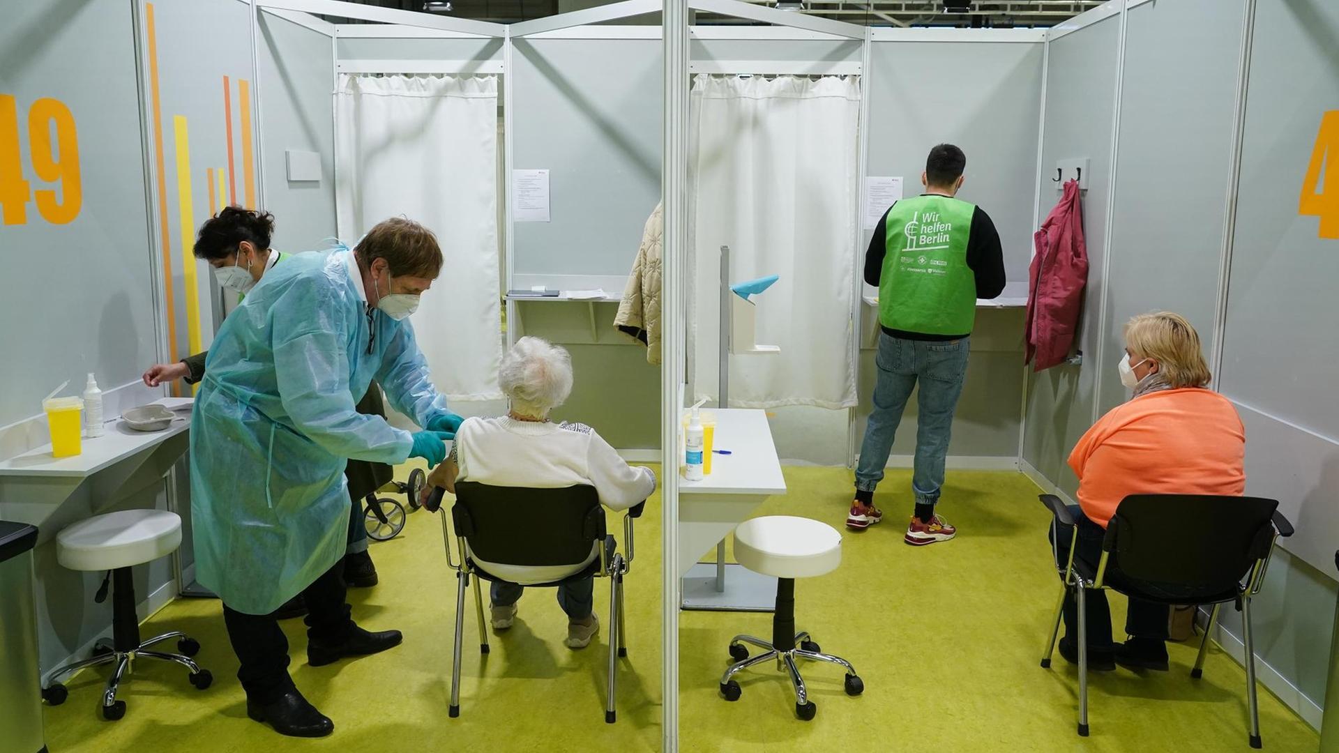 Ältere Menschen in nebeneinander liegenden Kabinen werden geimpft. Ältere Menschen in nebeneinander liegenden Kabinen werden geimpft.