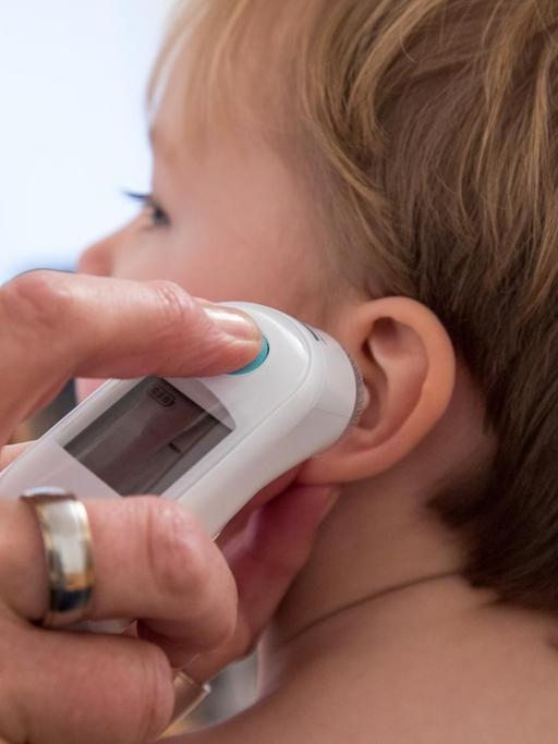 Eine Kinderaerztin untersucht einen kleinen Jungen (gestellte Szene).