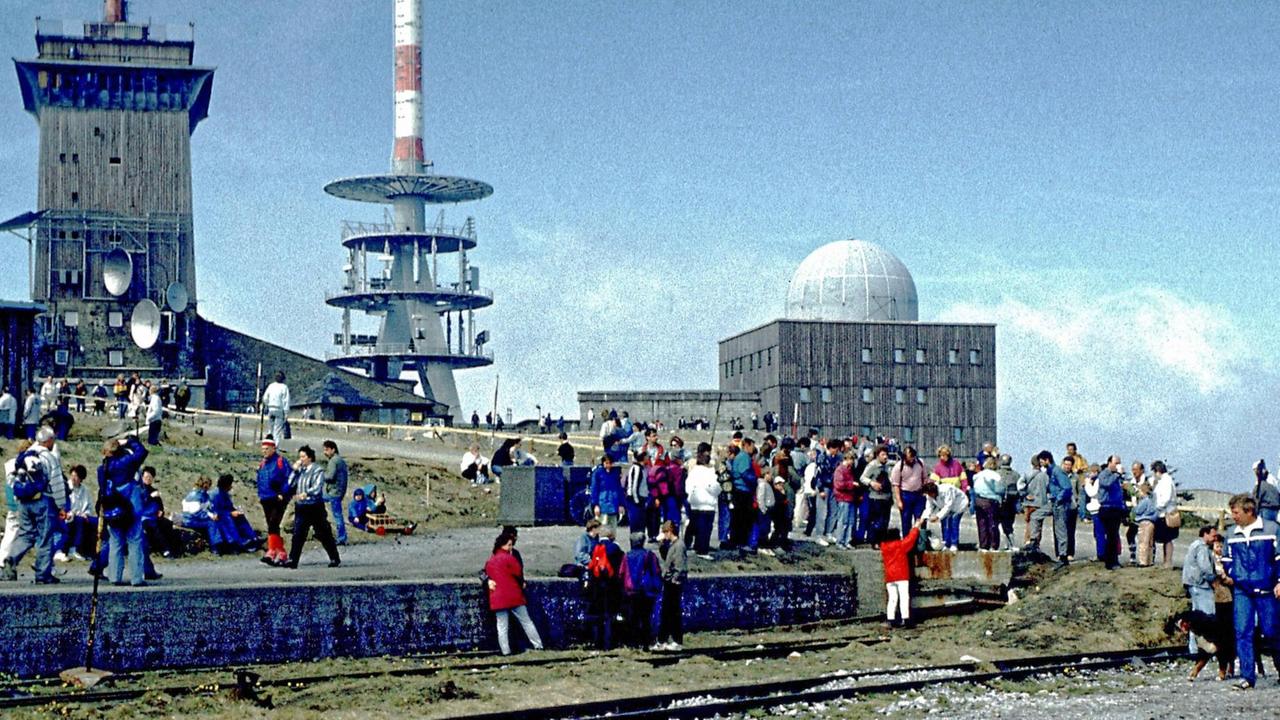 Touristen tummeln sich auf dem Gipfel des Brocken, auf dem die alte Stasi-Abhörstation gut zu sehen ist.