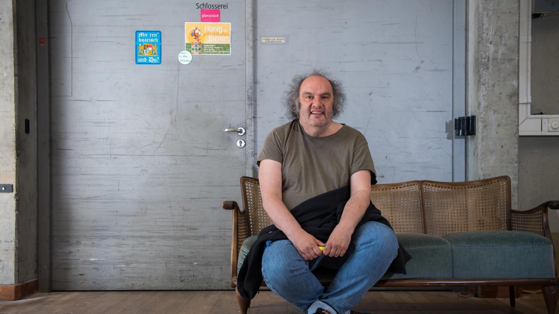 25.04.2018, Bayern, München: Matthias Lilienthal, Intendant der Münchner Kammerspiele, sitzt hinter der Bühne seines Hauses auf einer Requisiten-Sofa. 25.04.2018, Bayern, München: Matthias Lilienthal, Intendant der Münchner Kammerspiele, sitzt hinter der Bühne seines Hauses auf einer Requisiten-Sofa.