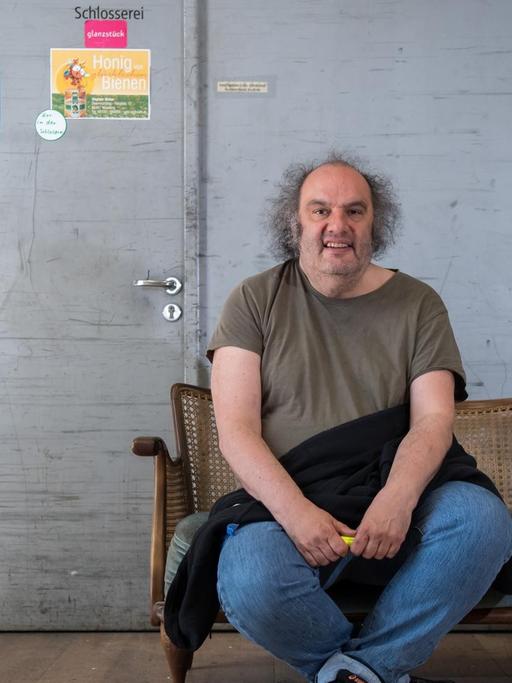 25.04.2018, Bayern, München: Matthias Lilienthal, Intendant der Münchner Kammerspiele, sitzt hinter der Bühne seines Hauses auf einer Requisiten-Sofa.