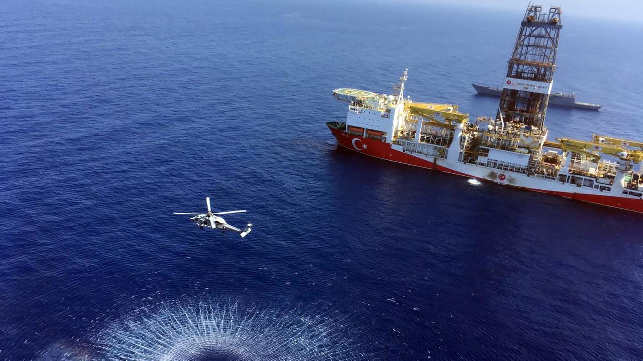 In this Tuesday, July 9, 2019 photo, a helicopter flies near Turkey's drilling ship, 'Fatih' dispatched towards the eastern Mediterranean, near Cyprus. Turkish officials say the drillships Fatih and Yavuz will drill for gas, which has prompted protests from Cyprus.(Turkish Defence Ministry via AP, Pool)