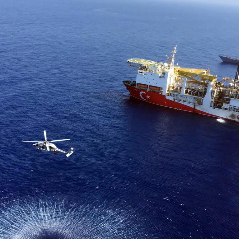 In this Tuesday, July 9, 2019 photo, a helicopter flies near Turkey's drilling ship, 'Fatih' dispatched towards the eastern Mediterranean, near Cyprus. Turkish officials say the drillships Fatih and Yavuz will drill for gas, which has prompted protests from Cyprus.(Turkish Defence Ministry via AP, Pool)
