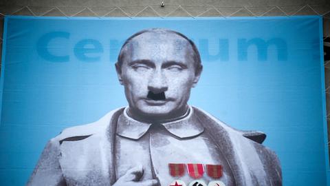 Eine Hitler-Karikatur vom russischen Präsidenten Putin auf einer Hauswand in Prag.