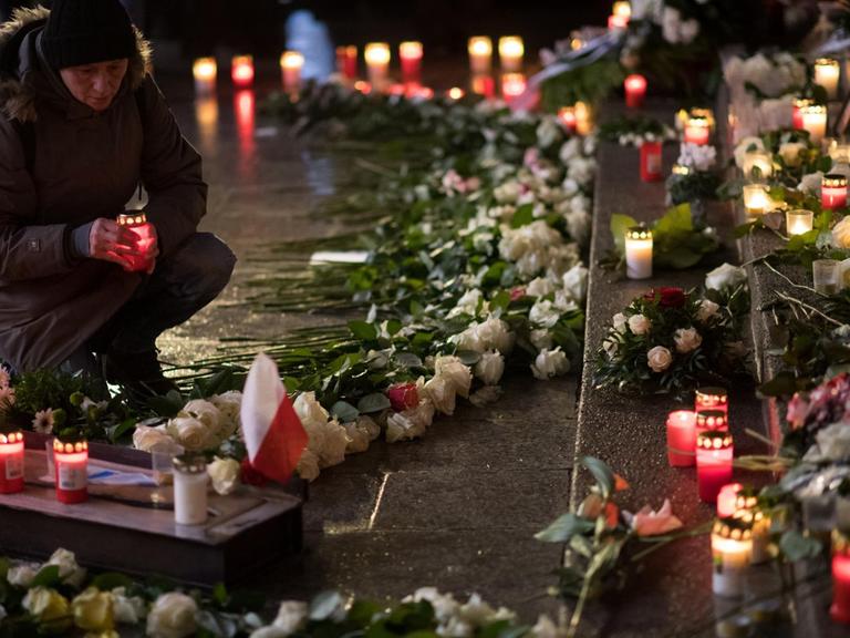 Eine Frau stellt am 19.12.2017 an der Gedenkstätte für die Opfer des islamistischen Terroranschlags auf dem Weihnachtsmarkt an der Gedächtniskirche auf dem Breitscheidplatz in Berlin eine Kerze auf. Bei dem Anschlag vor einem Jahr war der Attentäter Anis Amri mit einem gestohlenen Lastwagen in den Weihnachtsmarkt am Breitscheidplatz gefahren. Zwölf Menschen wurden getötet, fast 100 verletzt.
