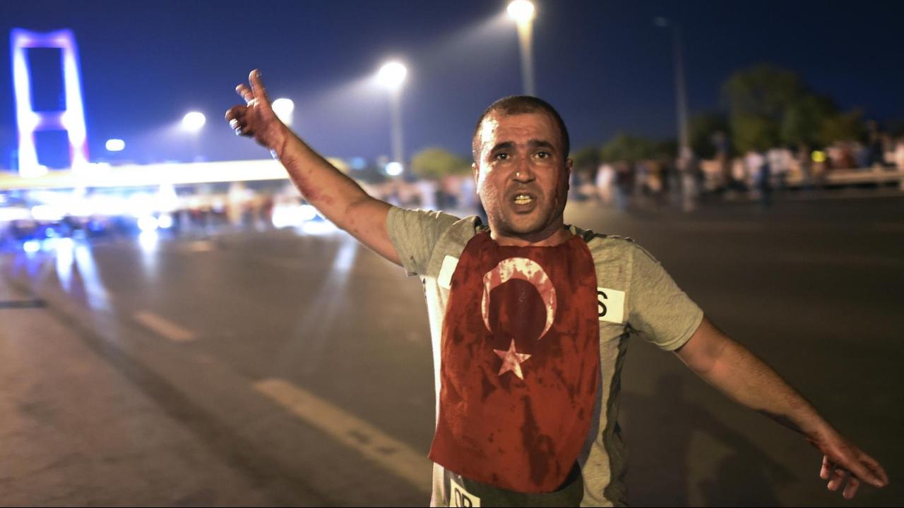 Ein Mann mit einer blutigen Türkeiflagge an der Bosporus-Brücke in Istanbul, wo Soldaten auf Putschgegner geschossen haben. Ein Mann mit einer blutigen Türkeiflagge an der Bosporus-Brücke in Istanbul, wo Soldaten auf Putschgegner geschossen haben.