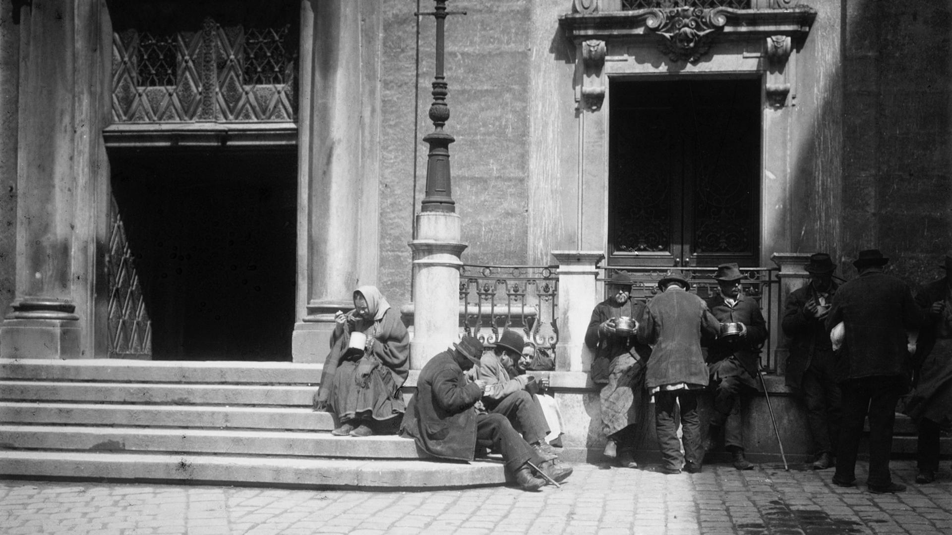 Bettler bei der Ausspeisung vor der Jesuitenkirche in Wien. Photographie um 1900