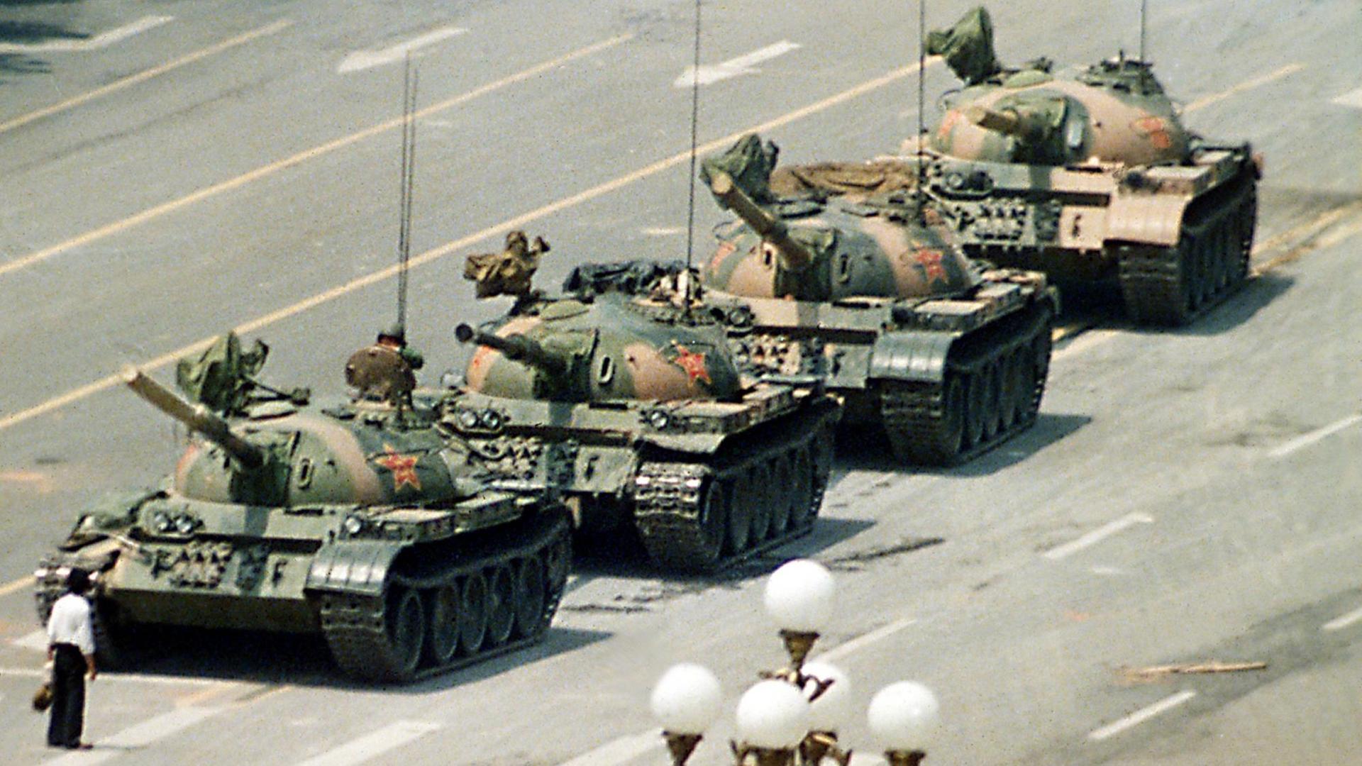 Am 5. Juni 1989 stellt sich ein Mann weinend vor die Panzer auf dem Tiananmen Platz in Peking. Er fleht darum, dass das Töten in Chinas Hauptstadt ein Ende nimmt. Außenstehende zogen ihn weg bevor die Panzer auf dem Cangan Boulevard am Beijing Hotel weiterrollen. Am 5. Juni 1989 stellt sich ein Mann weinend vor die Panzer auf dem Tiananmen Platz in Peking. Er fleht darum, dass das Töten in Chinas Hauptstadt ein Ende nimmt. Außenstehende zogen ihn weg bevor die Panzer auf dem Cangan Boulevard am Beijing Hotel weiterrollen.