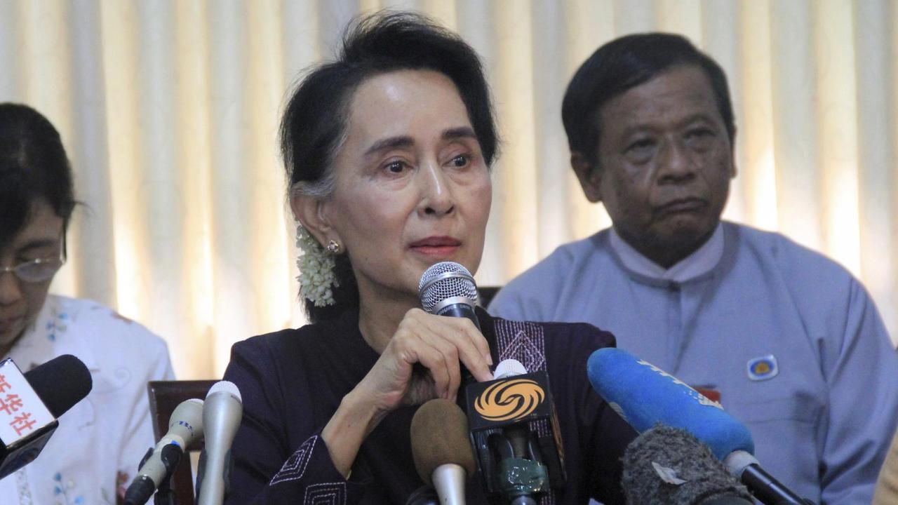 Aung San Suu Kyi steht vor vielen Mikrofonen.