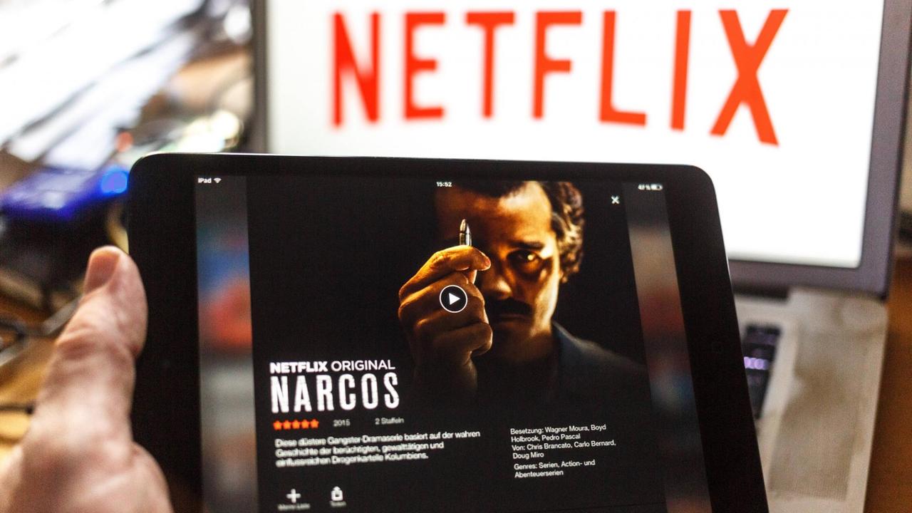 Das Netflix-Logo und der Trailer der Serie "Narcos" sind auf zwei Bildschirmen zu sehen.