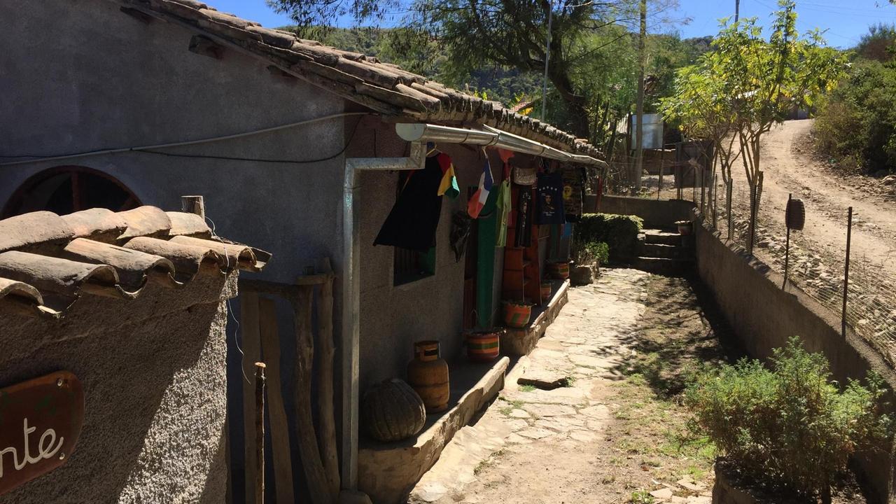 Eine staubige Straße und eine Holzhütte, die als Hostel für Che-Touristen dient in La Higuera.