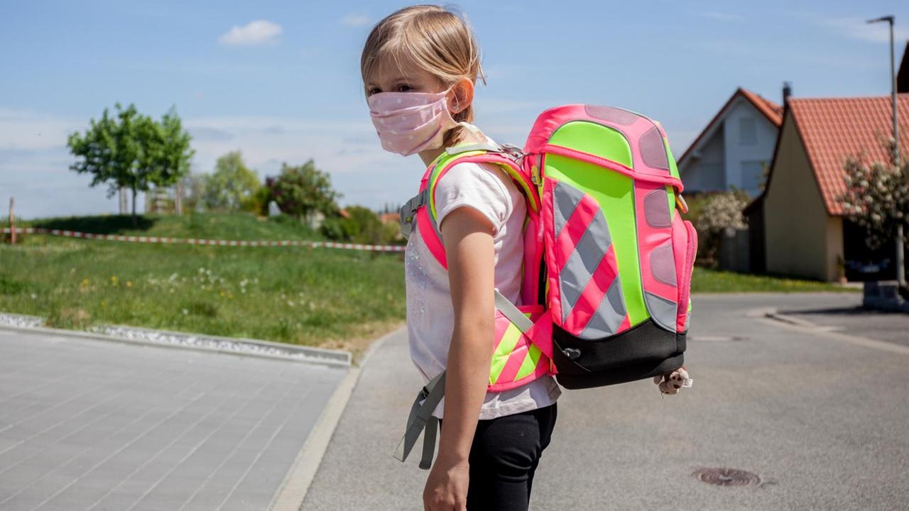 Mädchen mit Mundschutz und Schulrucksack Mädchen mit Mundschutz und Schulrucksack