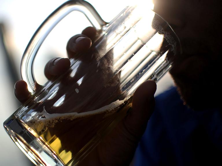 Ein junger Mann trinkt ein Glas Bier.