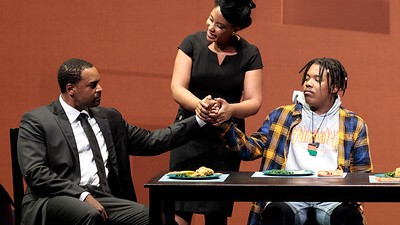 Szene aus der Oper "Blue" von Jeanine Tesori: Vater, Mutter und Sohn sitzen an einem Tisch Szene aus der Oper "Blue" von Jeanine Tesori: Vater, Mutter und Sohn sitzen an einem Tisch