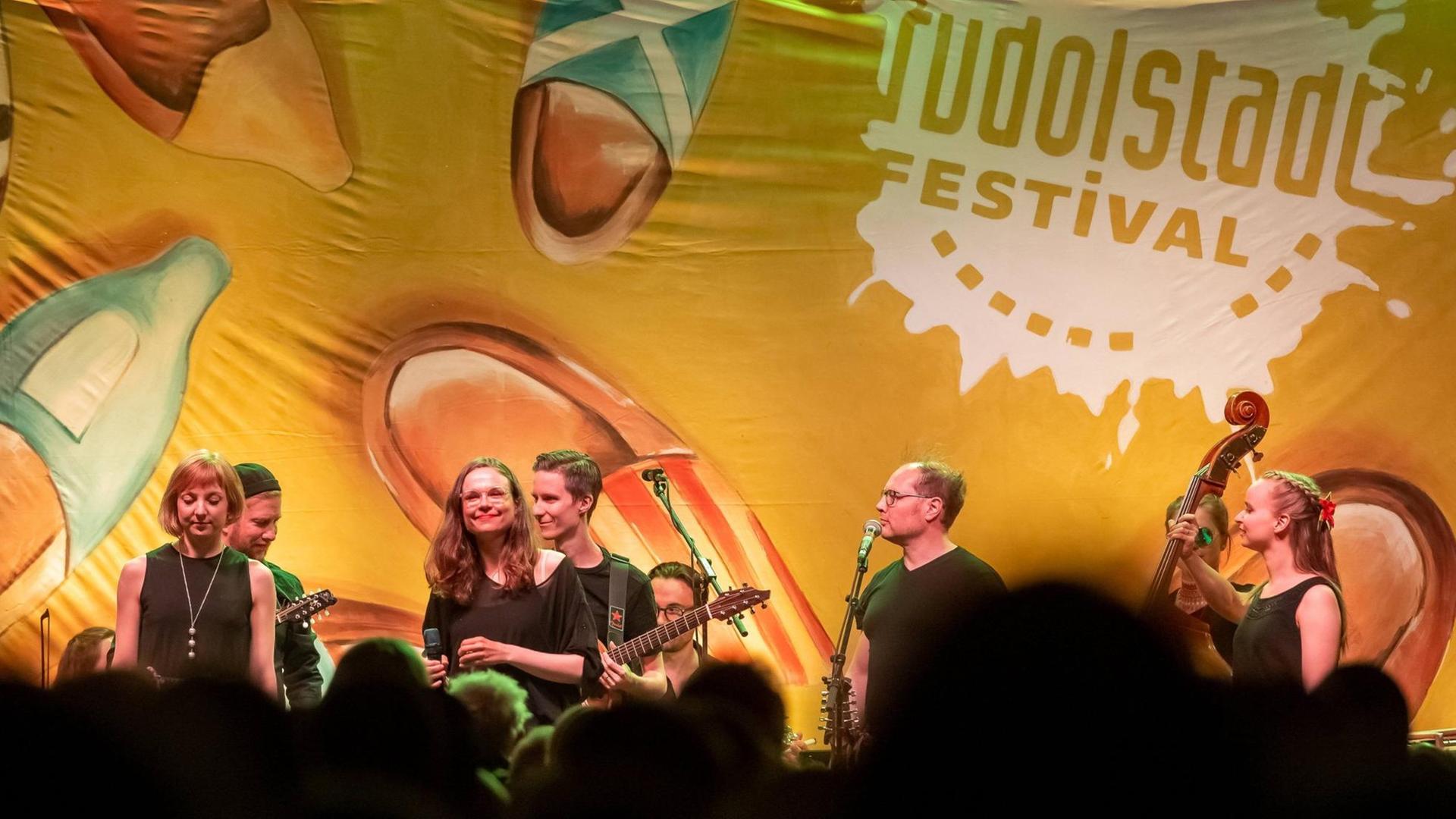 Eine Band steht auf der Bühne, auf dem Hintergrund ist der Namenszug des Festivals zu lesen. Eine Band steht auf der Bühne, auf dem Hintergrund ist der Namenszug des Festivals zu lesen.