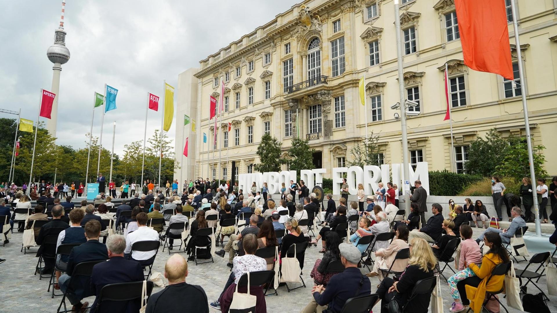 Viele Gäste sitzen auf Stühlen vor dem Gebäude. Viele Gäste sitzen auf Stühlen vor dem Gebäude.