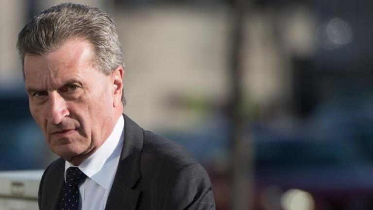 Oettinger steht im Freien und blickt ernst in die Kamera. Oettinger steht im Freien und blickt ernst in die Kamera.
