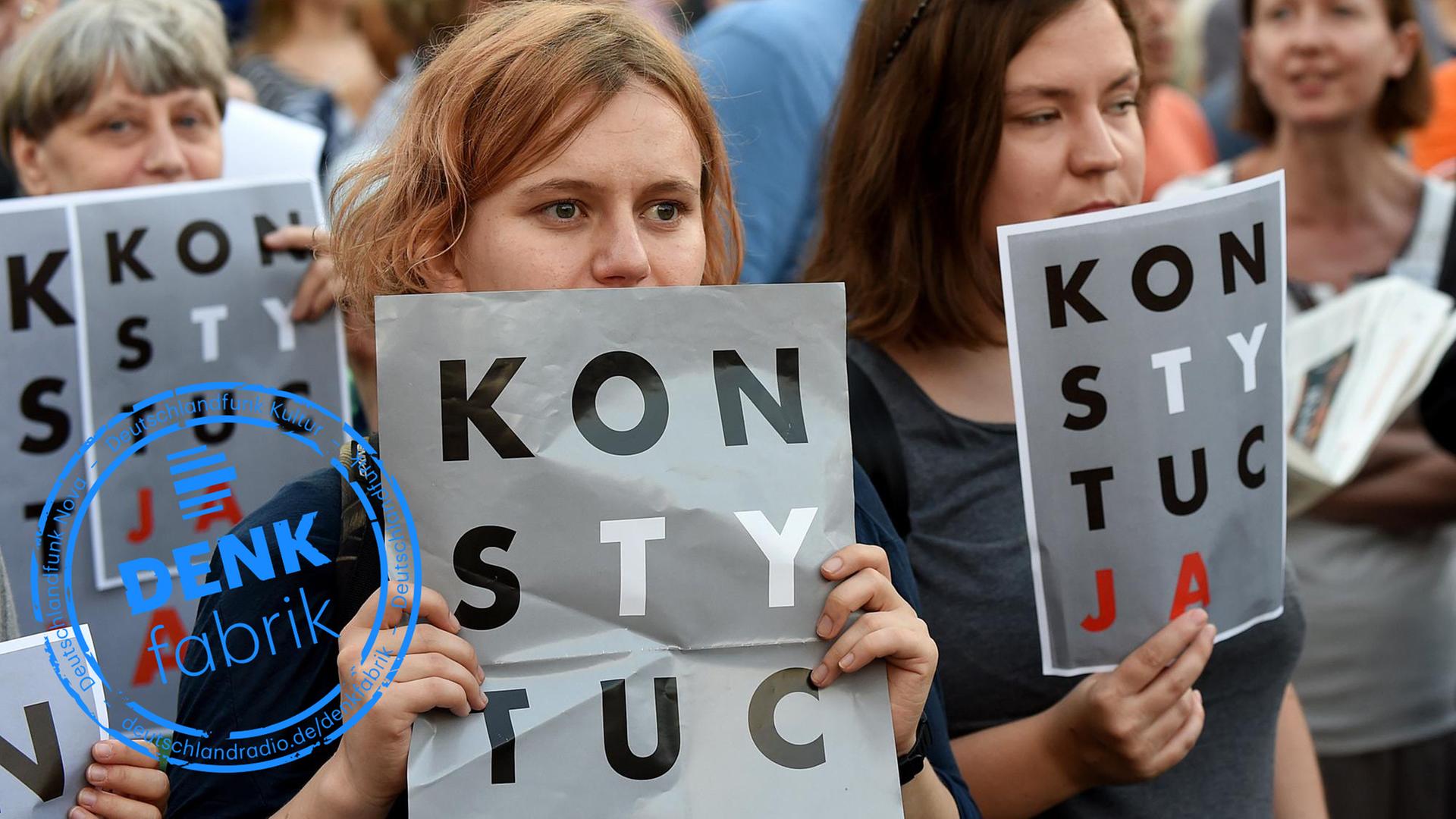 Demonstranten halten am 23.7.2017 vor dem Präsidentenpalast in Warschau Poster mit der Aufschrift "Verfassung" (auf Polnisch) in die Höhe. Demonstranten halten am 23.7.2017 vor dem Präsidentenpalast in Warschau Poster mit der Aufschrift "Verfassung" (auf Polnisch) in die Höhe.