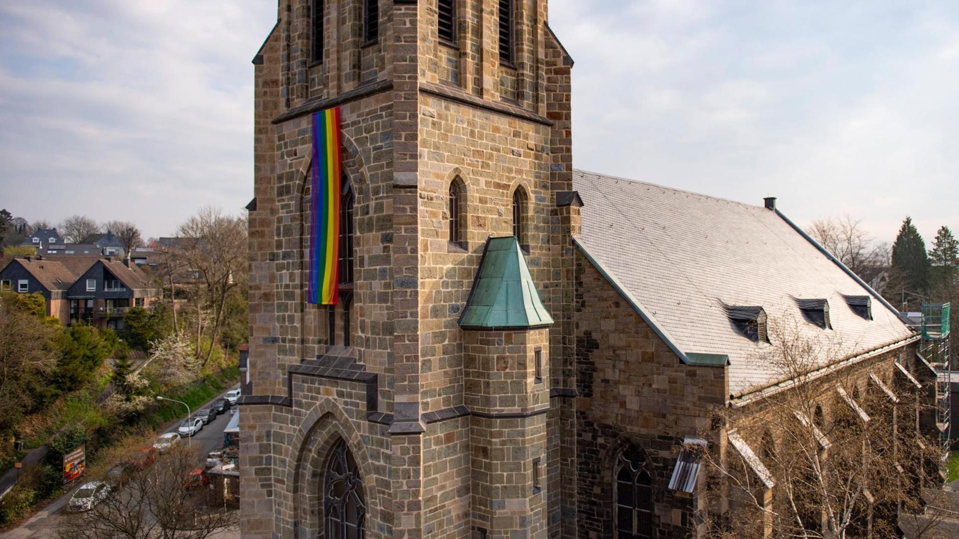 Eine Regenbogenfahne hängt an einem Kirchturm Eine Regenbogenfahne hängt an einem Kirchturm