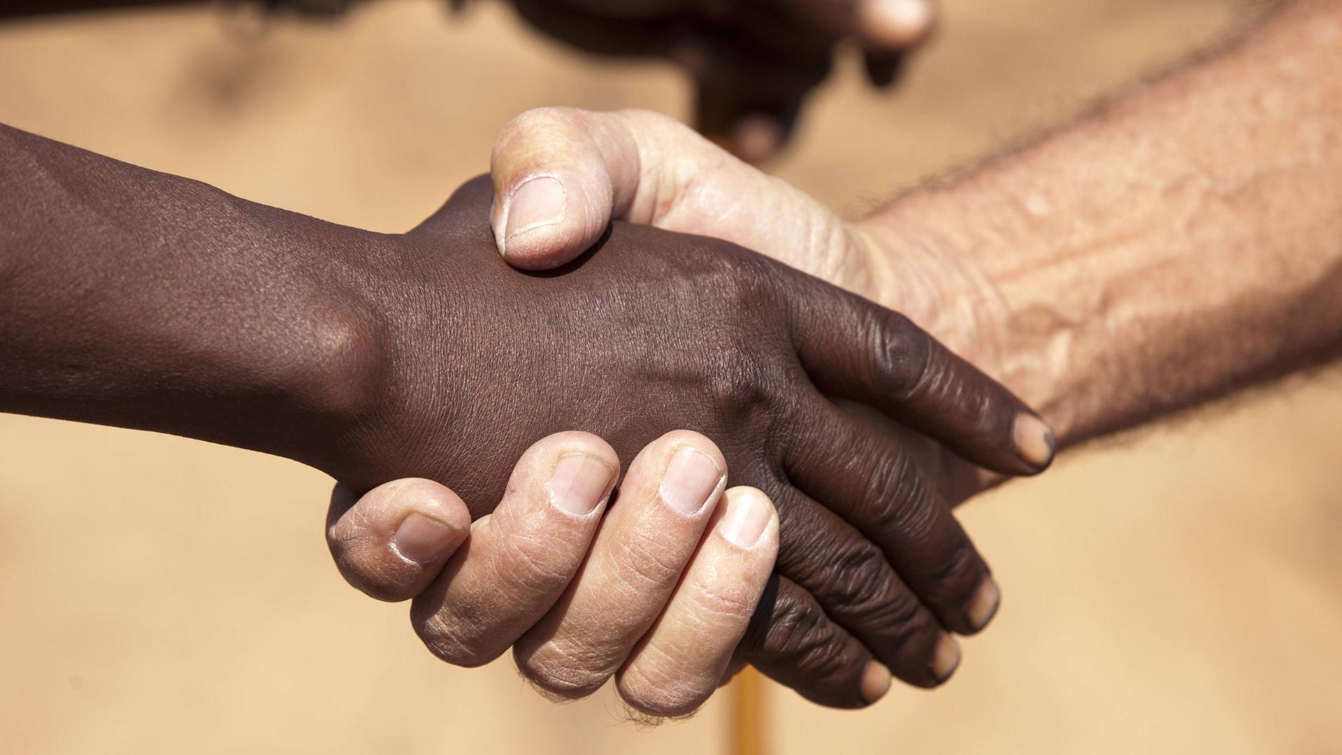Ein Handschlag zwischen einem Schwarzen und Weißen. Ein Handschlag zwischen einem Schwarzen und Weißen.