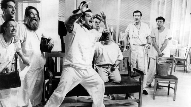 Der US-amerikanische Schauspieler Jack Nicholson (M) in einer Szene des Milos-Forman-Films "Einer flog über das Kuckucksnest" aus dem Jahr 1979. Nicholson spielt den Strafgefangenen McMurphy, der - um einem Arbeitslager zu entgehen - "verrückt" spielt und sich in eine Nervenheilanstalt einweisen läßt. Zunächst kann er Spaß und Abwechslung in den monotonen und oft unmenschlichen Alltag der Heiminsassen bringen, doch schließlich scheitert er und wird durch eine Gehirnoperation seiner Persönlichkeit beraubt. Der Film, entstanden nach dem Bestseller-Roman von Ken Kesey, wurde 1976 mit vier Oscars ausgezeichnet (Regie, bester Film, beste/r Hauptdarsteller/in). |