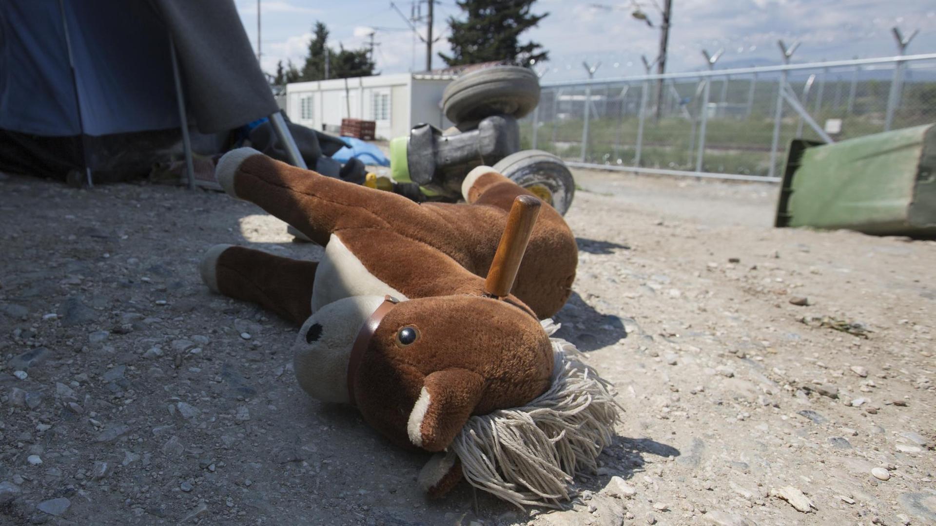 Ein Spielzeugpferd liegt vor dem Eingang eines Zeltes im Flüchtlinglager Idomeni, Griechenland.