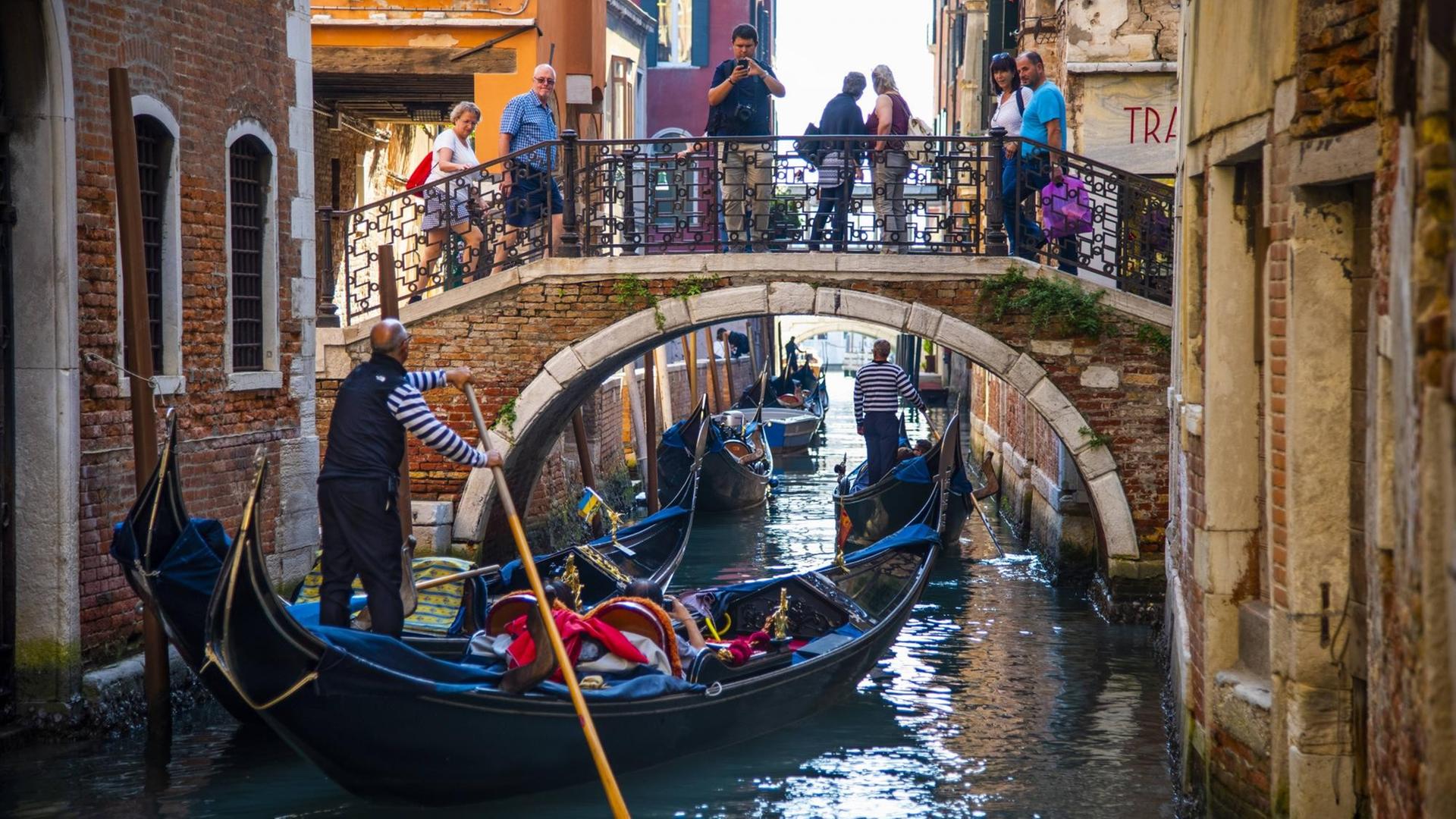 Touristen in einer Gondel erkunden Venedig.