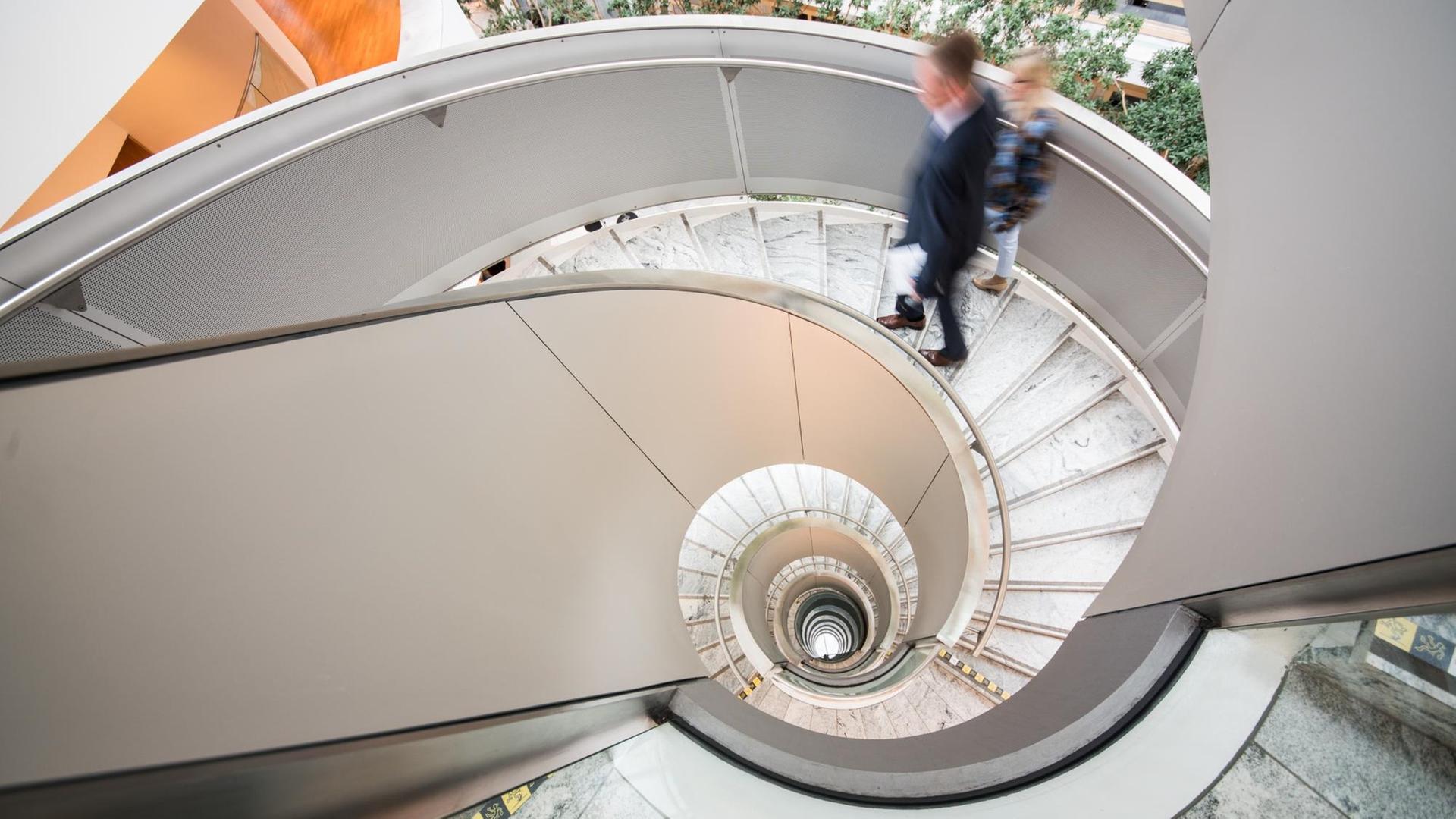 Zwei Mitarbeiter gehen in der Hauptverwaltung bei Boehringer Ingelheim eine Wendeltreppe hoch, aufgenommen im April 2019 Zwei Mitarbeiter gehen in der Hauptverwaltung bei Boehringer Ingelheim eine Wendeltreppe hoch, aufgenommen im April 2019