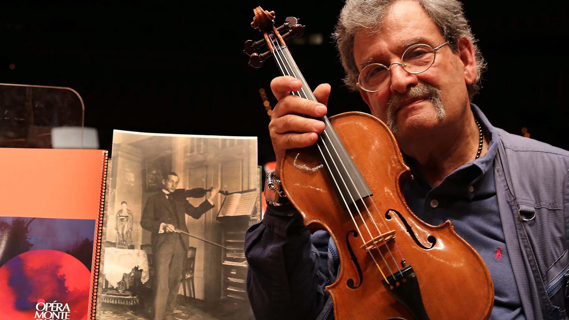 Geigenbauer Amnon Weinstein mit einer von ihm restaurierten Violine bei der Ausstellung "Violins of Hope" in Monaco. Geigenbauer Amnon Weinstein mit einer von ihm restaurierten Violine bei der Ausstellung "Violins of Hope" in Monaco.