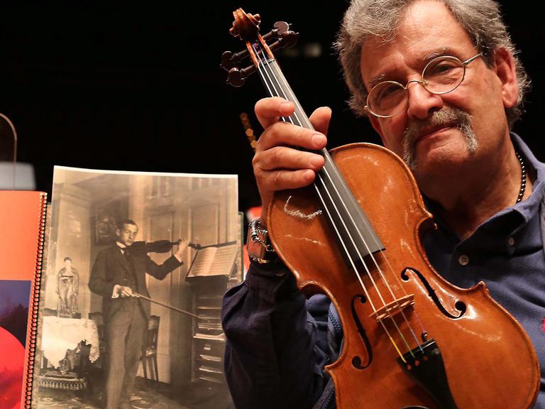 Geigenbauer Amnon Weinstein mit einer von ihm restaurierten Violine bei der Ausstellung "Violins of Hope" in Monaco.
