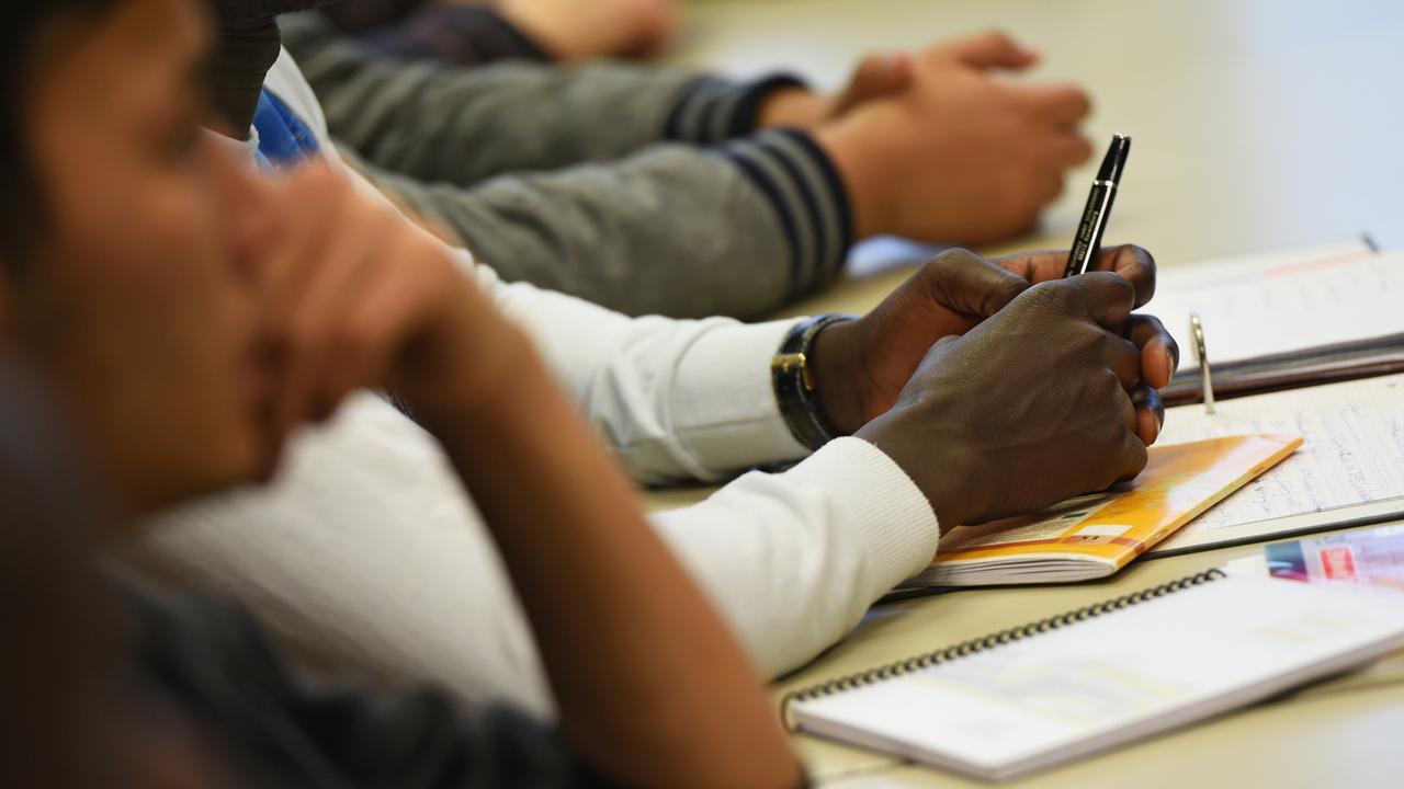 Eine gemischte Klasse, bestehend aus aus Zuwanderern, Flüchtlingen und ehemalige Flüchtlingen, hat am 17.11.2015 in der Edith-Stein-Schule in Ravensburg (Baden-Württemberg) Unterricht. Ziel ist das Erreichen des Hauptschulabschlusses. Foto: Felix Kästle/dpa (zu lsw Meldung: «Lehrer stoßen an ihre Belastungsgrenze» vom 19.11.2015) Eine gemischte Klasse, bestehend aus aus Zuwanderern, Flüchtlingen und ehemalige Flüchtlingen, hat am 17.11.2015 in der Edith-Stein-Schule in Ravensburg (Baden-Württemberg) Unterricht. Ziel ist das Erreichen des Hauptschulabschlusses. Foto: Felix Kästle/dpa (zu lsw Meldung: «Lehrer stoßen an ihre Belastungsgrenze» vom 19.11.2015)