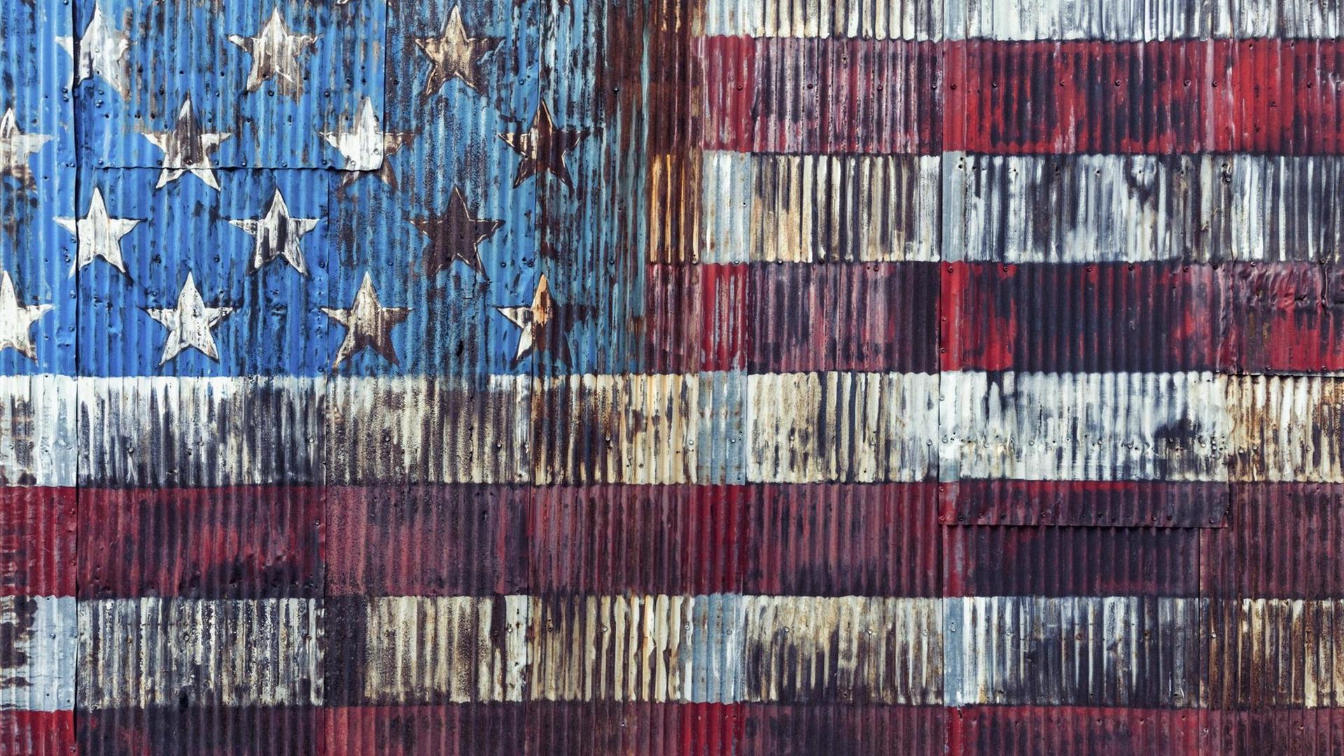 Eine verrostete amerikanische Flagge an einer Wand in New York City. Eine verrostete amerikanische Flagge an einer Wand in New York City.
