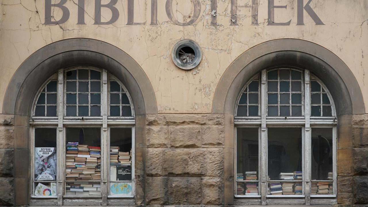 Blick auf das leerstehende Gebäude der Bibliothek in der sachsenanhaltinischen Stadt Zeitz, deren Fenster mit alten Büchern zugestellt sind. 
