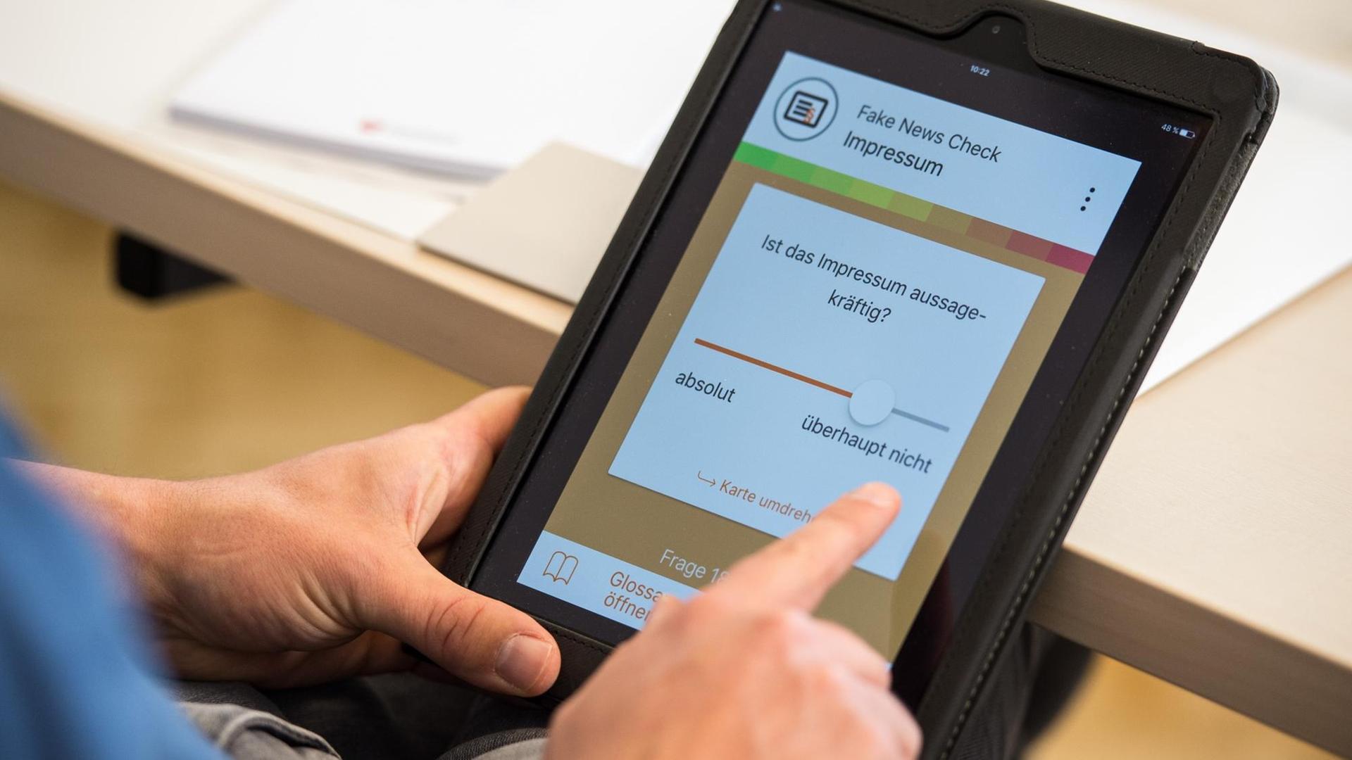 Ein Mann hält am 23.05.2017 bei einer Pressekonferenz in Hannover (Niedersachsen) ein Tablet mit einer App zur Überprüfung von Fake News in den Händen. Niedersachsens Kultusministerin Heiligenstadt (SPD) stellte neu entwickelte Unterrichtsmaterialien zum Thema «Fake News und Social Bots im digitalen Zeitalter» vor. Mit einer App können Schüler Texte in Gestalt einer «Fake News Ampel» auf ihren Wahrheitsgehalt überprüfen lassen. Ein Mann hält am 23.05.2017 bei einer Pressekonferenz in Hannover (Niedersachsen) ein Tablet mit einer App zur Überprüfung von Fake News in den Händen. Niedersachsens Kultusministerin Heiligenstadt (SPD) stellte neu entwickelte Unterrichtsmaterialien zum Thema «Fake News und Social Bots im digitalen Zeitalter» vor. Mit einer App können Schüler Texte in Gestalt einer «Fake News Ampel» auf ihren Wahrheitsgehalt überprüfen lassen.