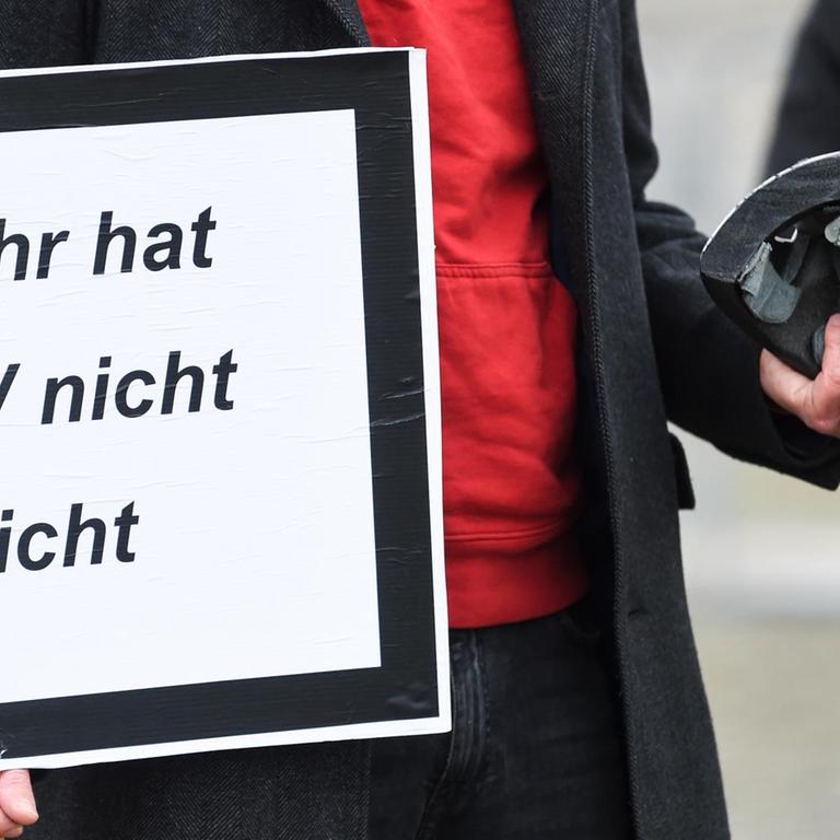 Ein Demonstrant hält ein Schild mit der Aufschrift "Für mehr hat Hartz-IV nicht gereicht" und einen halben Fahrradhelm in der Hand. Vor dem Deutschen Bundestag demonstrieren Personen der Aktion «Keine halben Sachen: Corona-Hilfen für die Ärmsten» für mehr Corona-Hilfen.