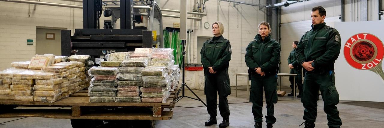 Zollfahnder stehen am 03.02.2017 in Hamburg neben einem Gabelstapler, der eine Palette mit Kokain-Päckchen trägt. Im Hamburger Hafen wurde ein Container sichergestellt, der 717 Kilo Kokain mit einem Verkaufswert von 145 Millionen Euro. Es sei die größte je in Deutschland beschlagnahmte Menge an Kokain, sagte der Leiter des Zollfahndungsamtes. Zollfahnder stehen am 03.02.2017 in Hamburg neben einem Gabelstapler, der eine Palette mit Kokain-Päckchen trägt. Im Hamburger Hafen wurde ein Container sichergestellt, der 717 Kilo Kokain mit einem Verkaufswert von 145 Millionen Euro. Es sei die größte je in Deutschland beschlagnahmte Menge an Kokain, sagte der Leiter des Zollfahndungsamtes.