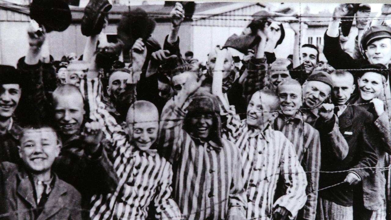 Häftlinge des KZ Dachau jubeln bei ihrer Befreiung durch amerikanische Truppen am 29. April 1945 Häftlinge des KZ Dachau jubeln bei ihrer Befreiung durch amerikanische Truppen am 29. April 1945