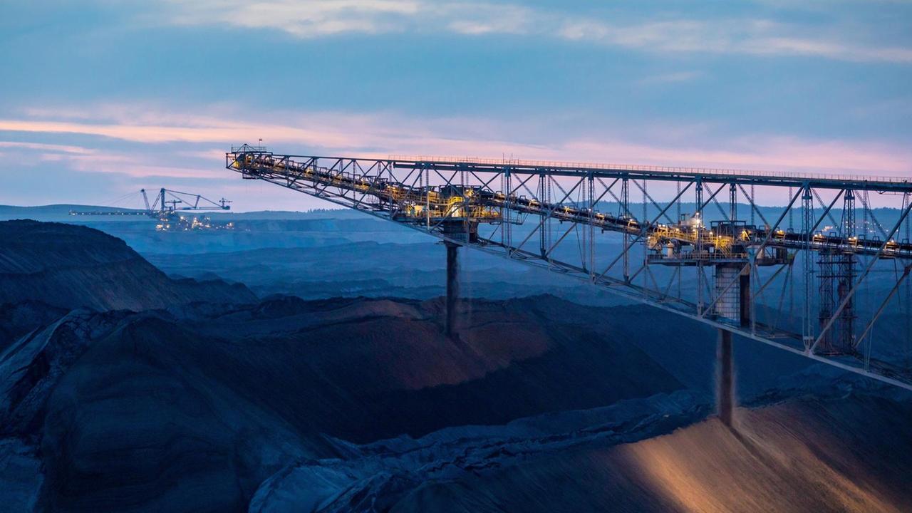 Bagger im Tagebau Welzow-Süd in der Dämmerung: Der Himmel im Hintergrund schimmert bläulich. Bagger im Tagebau Welzow-Süd in der Dämmerung: Der Himmel im Hintergrund schimmert bläulich.