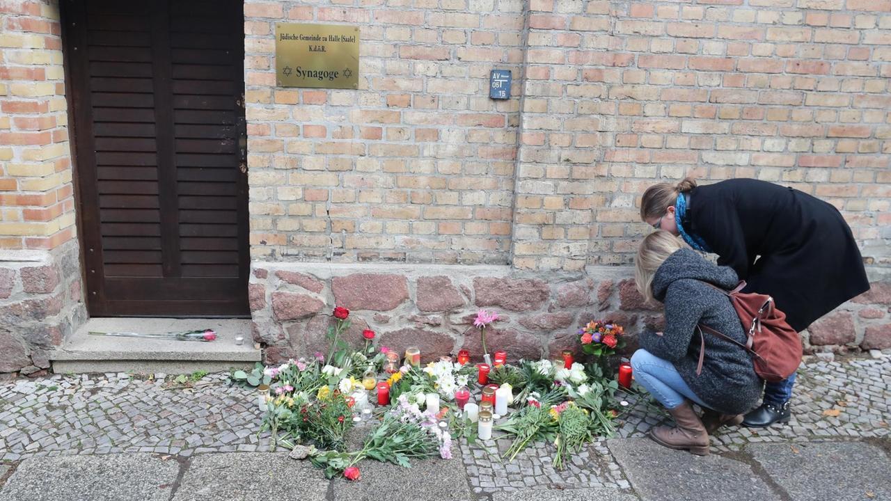 Menschen legen Blumen vor der Synagoge in Halle ab. Menschen legen Blumen vor der Synagoge in Halle ab.