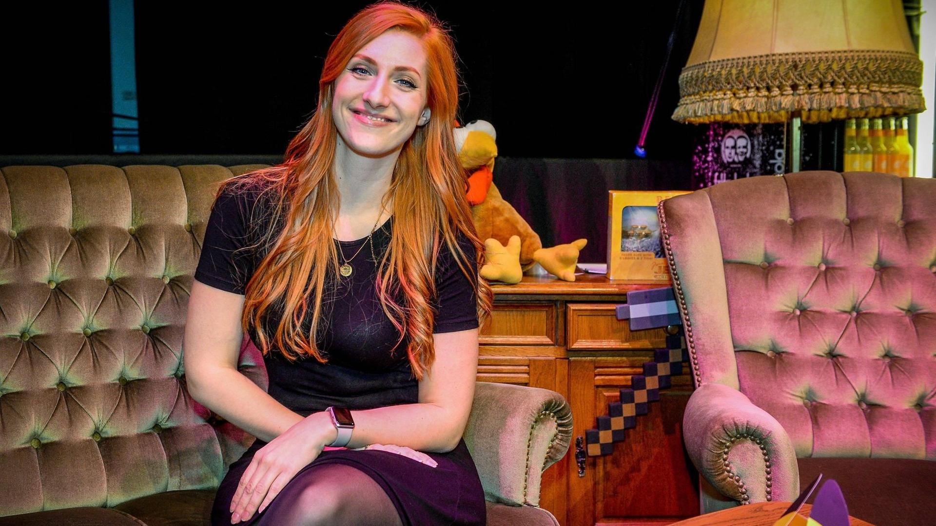 Die Let´s Playerin und Schauspielerin Lara Loft (Lara Trautmann) sitzt auf einem antiken Sofa vor ihr auf dem Tisch ein Spiele-Controller. Die Let´s Playerin und Schauspielerin Lara Loft (Lara Trautmann) sitzt auf einem antiken Sofa vor ihr auf dem Tisch ein Spiele-Controller.