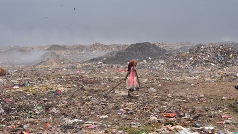 Ein Mädchen sammelt Abfälle auf einem Müllberg vor Delhi.