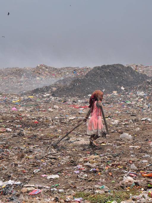 Ein Mädchen sammelt Abfälle auf einem Müllberg vor Delhi.