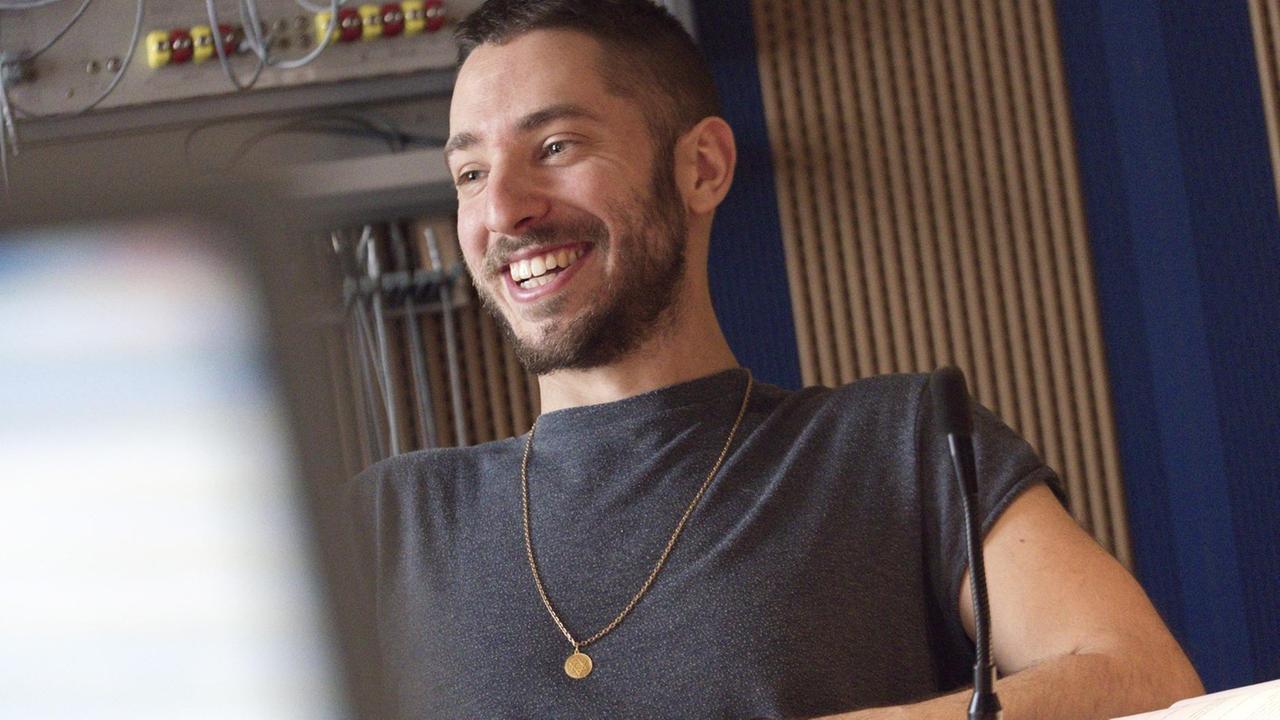 Hörspiel-Regisseur Noam Brusilovsky sitzt im Studio und lacht. Hörspiel-Regisseur Noam Brusilovsky sitzt im Studio und lacht.