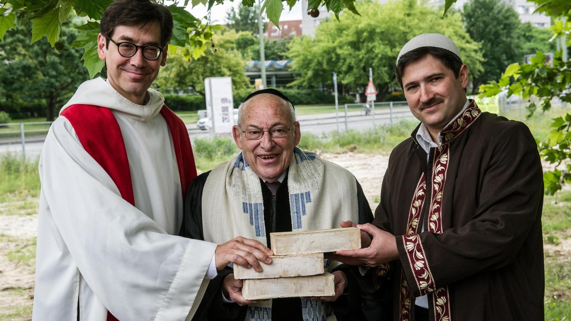 Der Pfarrer Gregor Hohberg, der Rabbiner Tovia Ben-Chorin und der Imam Kadir Sanci halten auf dem Petriplatz gemeinsam drei Ziegelsteine in den Händen. Der Pfarrer Gregor Hohberg, der Rabbiner Tovia Ben-Chorin und der Imam Kadir Sanci halten auf dem Petriplatz gemeinsam drei Ziegelsteine in den Händen.